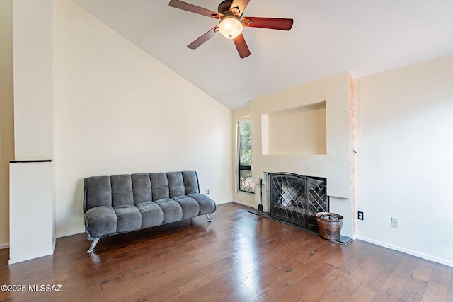 living area with lofted ceiling, a ceiling fan, hardwood / wood-style floors, a fireplace, and baseboards