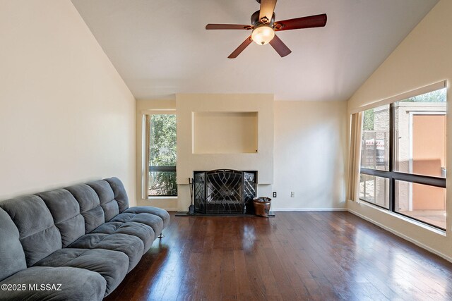 living room with dark wood finished floors, a healthy amount of sunlight, and vaulted ceiling