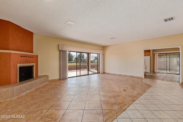 unfurnished living room featuring light tile patterned floors, a fireplace, visible vents, and a textured ceiling