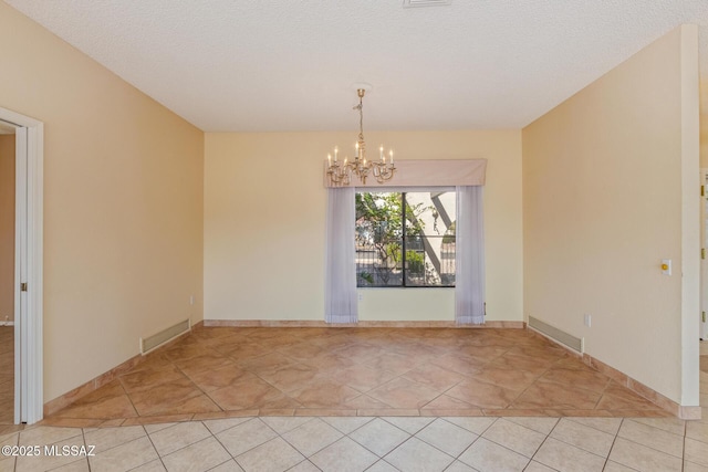 spare room with a notable chandelier, visible vents, light tile patterned floors, and a textured ceiling