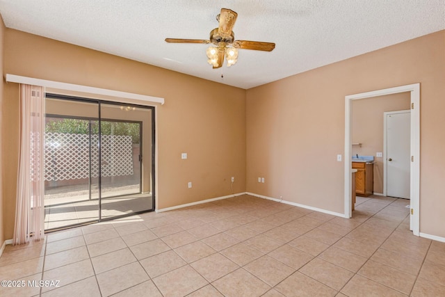 empty room with baseboards, a textured ceiling, light tile patterned flooring, and a ceiling fan