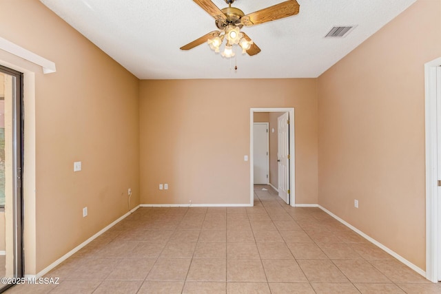 unfurnished room with light tile patterned floors, baseboards, visible vents, and ceiling fan