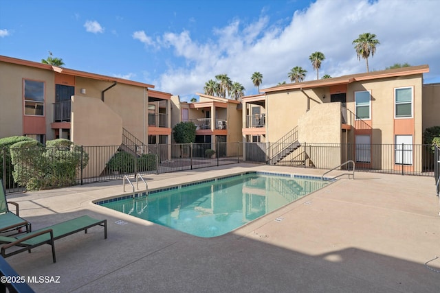 community pool featuring fence and a patio