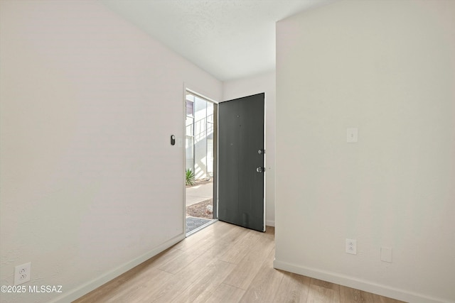 unfurnished room with light wood finished floors and baseboards