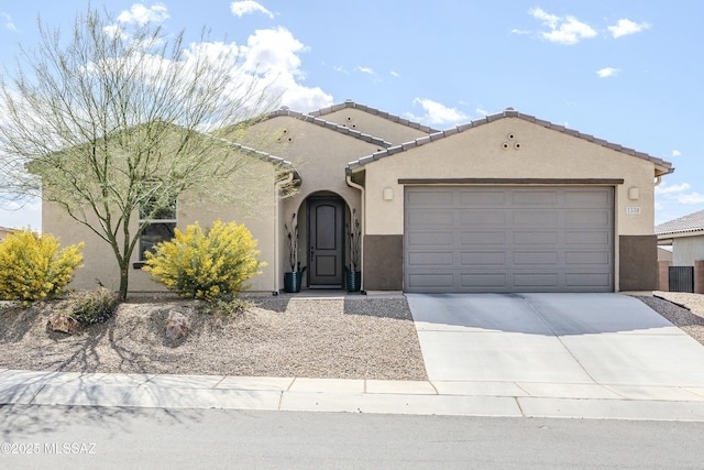 mediterranean / spanish-style house featuring concrete driveway, a garage, and stucco siding