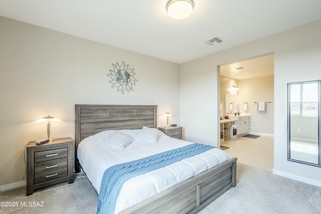 bedroom with visible vents, baseboards, carpet, and ensuite bath