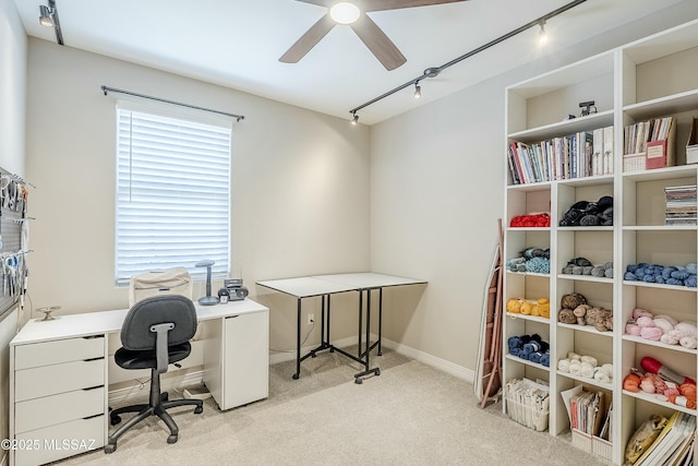 carpeted office featuring baseboards, track lighting, and a ceiling fan