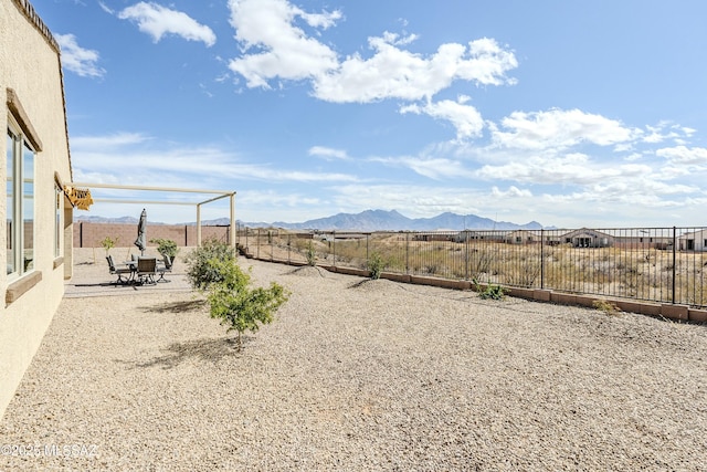 view of yard with a mountain view, a patio, and a fenced backyard