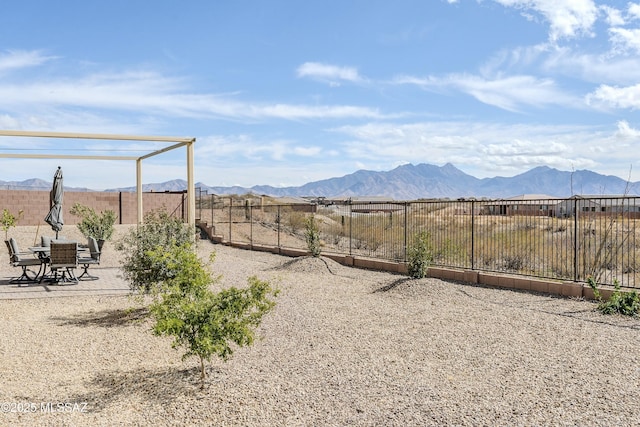 view of yard featuring a patio, a fenced backyard, and a mountain view