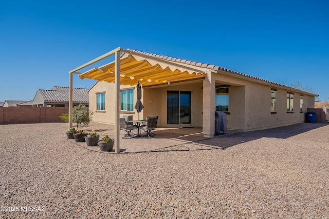 back of property featuring stucco siding, a patio, and fence