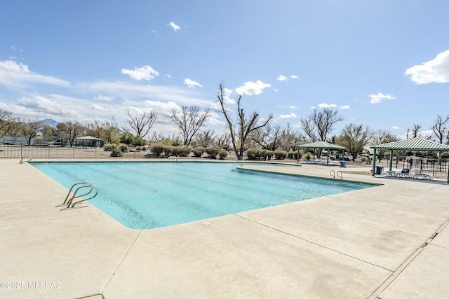 pool featuring a gazebo, fence, and a patio area