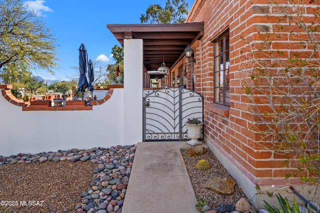 property entrance with a gate and brick siding