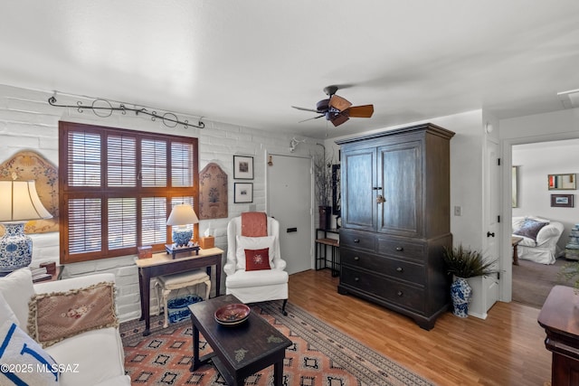 sitting room featuring light wood-type flooring and a ceiling fan