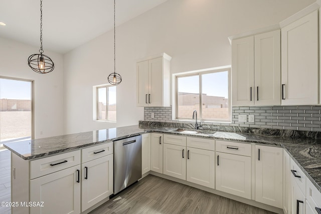 kitchen with a sink, a peninsula, white cabinets, and dishwasher