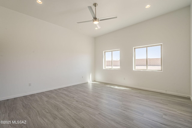 unfurnished room featuring recessed lighting, wood finished floors, and baseboards