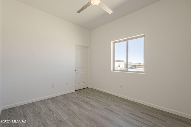 unfurnished room featuring ceiling fan, baseboards, and wood finished floors