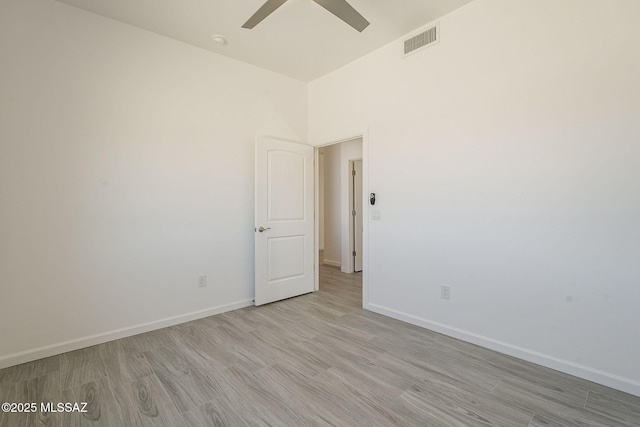 spare room featuring visible vents, ceiling fan, baseboards, and wood finished floors