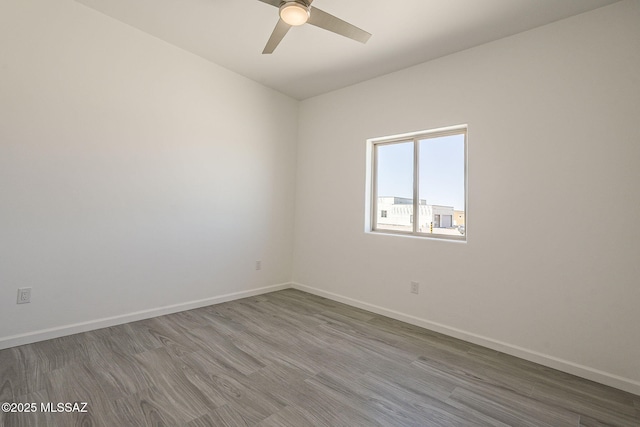 spare room with ceiling fan, baseboards, and wood finished floors