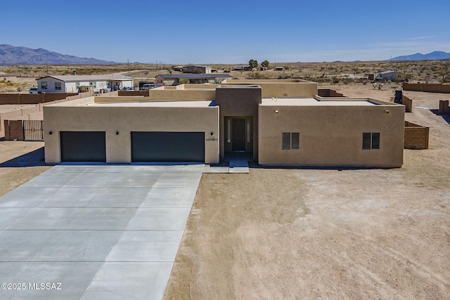 adobe home featuring driveway, a mountain view, and stucco siding