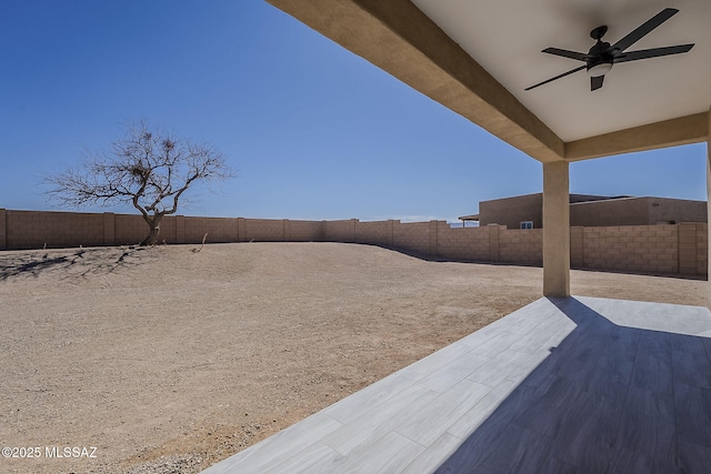 view of yard featuring a patio area, ceiling fan, and a fenced backyard