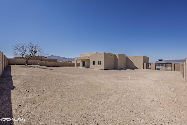 back of house featuring a fenced backyard and stucco siding