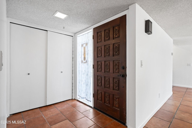 tiled entryway with a textured ceiling