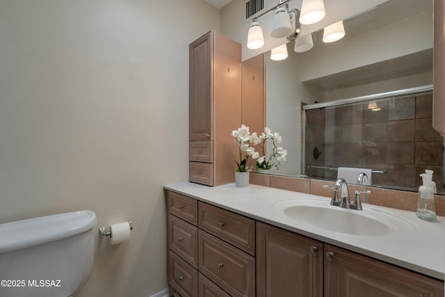 bathroom with a stall shower, visible vents, vanity, and toilet