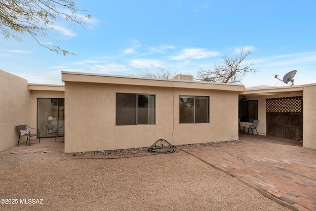 back of property with a patio area and stucco siding