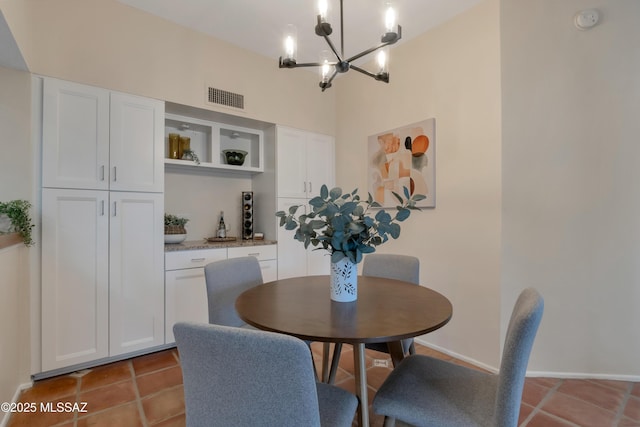 dining space with a high ceiling, tile patterned flooring, visible vents, and a notable chandelier