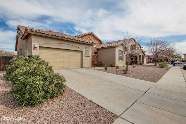 mediterranean / spanish-style home with driveway, a tile roof, and stucco siding