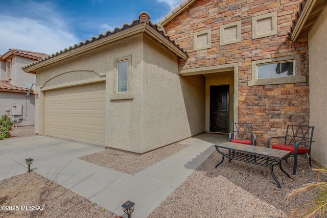 view of front facade with driveway, an attached garage, a tile roof, and stucco siding