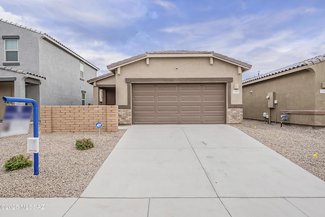 view of front of home featuring an attached garage, stucco siding, concrete driveway, and brick siding