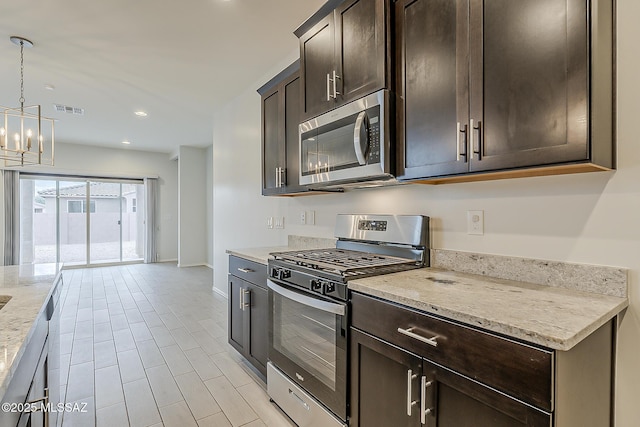 kitchen featuring dark brown cabinetry, visible vents, light stone counters, hanging light fixtures, and stainless steel appliances