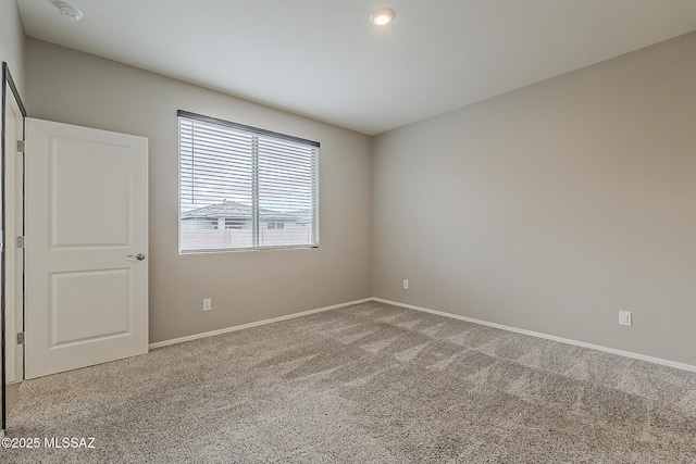 spare room with carpet and baseboards