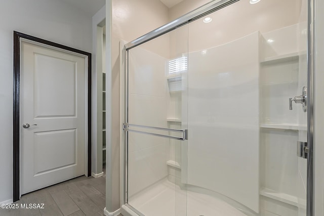 full bathroom featuring a stall shower and wood finished floors