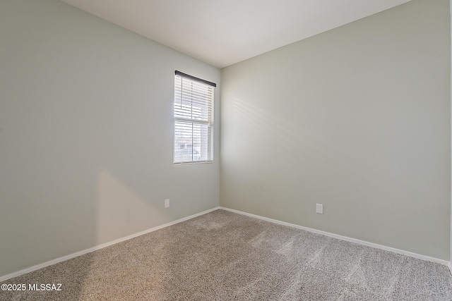 empty room featuring carpet flooring and baseboards