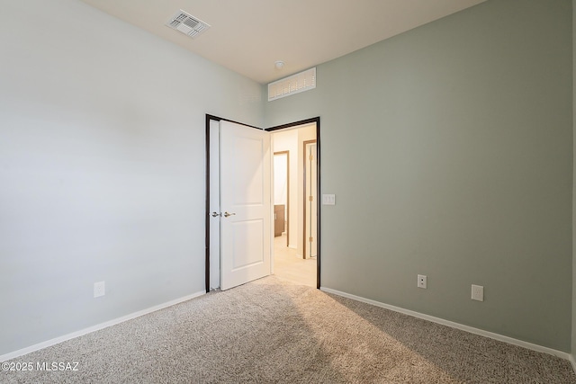 unfurnished bedroom with visible vents, light carpet, and baseboards