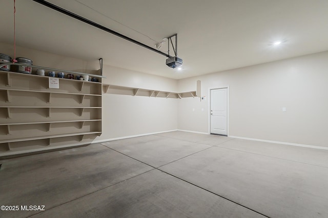 garage with baseboards and a garage door opener