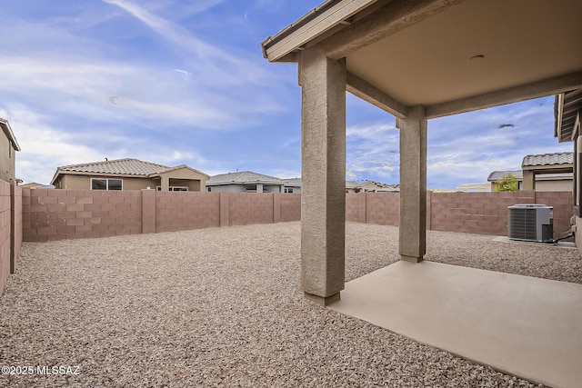 view of yard with a patio area, central AC, and a fenced backyard