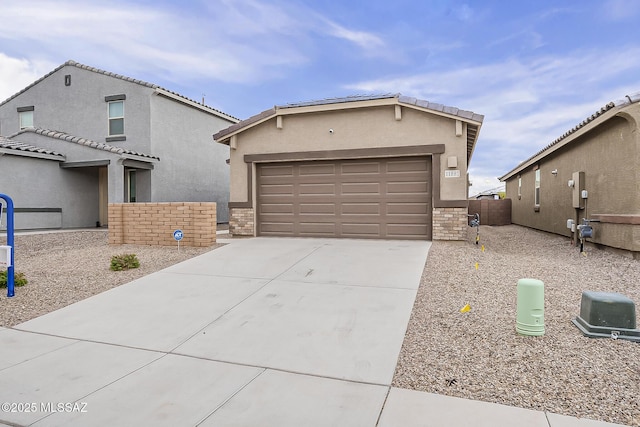 view of front of home with fence, concrete driveway, stone siding, a tiled roof, and stucco siding