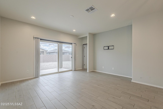 empty room with light wood-type flooring, baseboards, visible vents, and recessed lighting