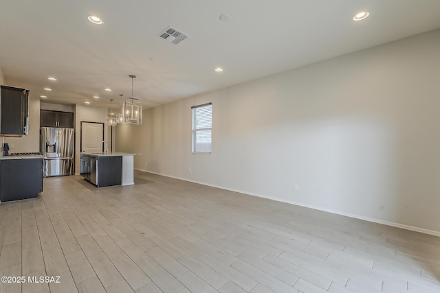 kitchen featuring visible vents, light wood-style floors, open floor plan, light countertops, and stainless steel fridge with ice dispenser