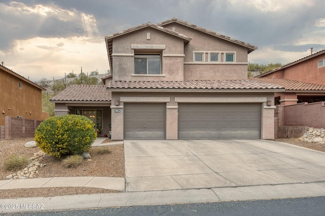 view of front of house with a garage, driveway, a tile roof, fence, and stucco siding