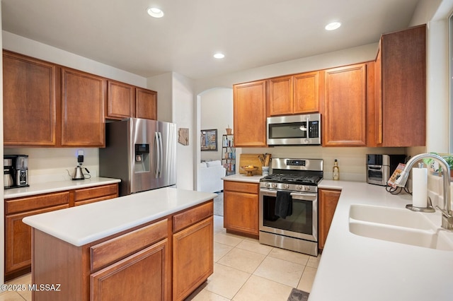 kitchen featuring light tile patterned floors, recessed lighting, light countertops, appliances with stainless steel finishes, and a sink