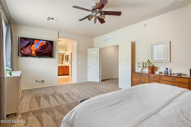 carpeted bedroom featuring arched walkways, visible vents, and baseboards