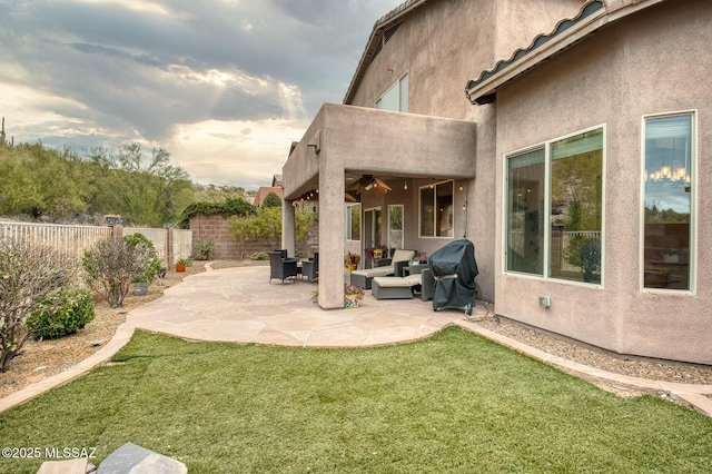 exterior space featuring a ceiling fan, a fenced backyard, and grilling area