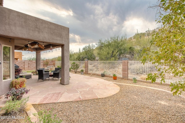 view of patio with a fenced backyard and a ceiling fan