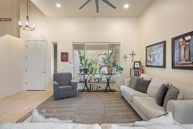 living area with recessed lighting, light tile patterned flooring, a towering ceiling, and ceiling fan with notable chandelier