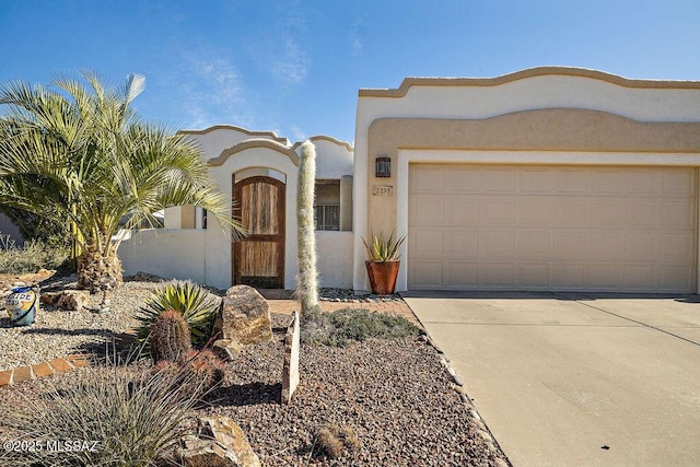 view of front of home with driveway, an attached garage, and stucco siding