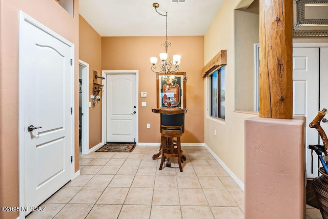 foyer featuring a chandelier, visible vents, baseboards, and light tile patterned floors